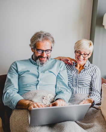couple sitting on couch with computer
